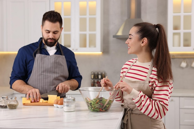 Una feliz y encantadora pareja cocinando juntos en la cocina.