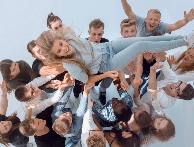 Feliz equipo de jóvenes balanceando a su líder