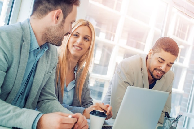 Foto feliz equipo de negocios sonriente en la oficina