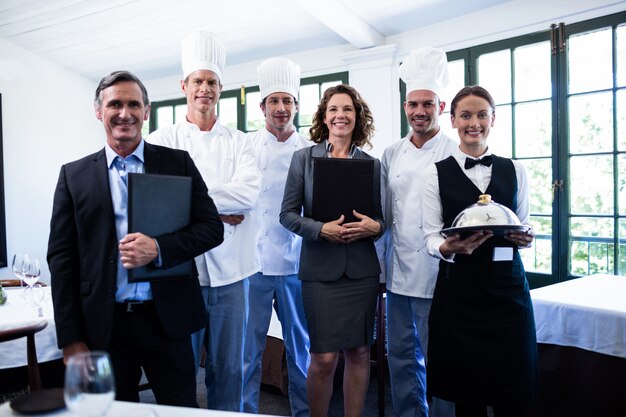 Feliz equipo de restaurante de pie juntos en el restaurante