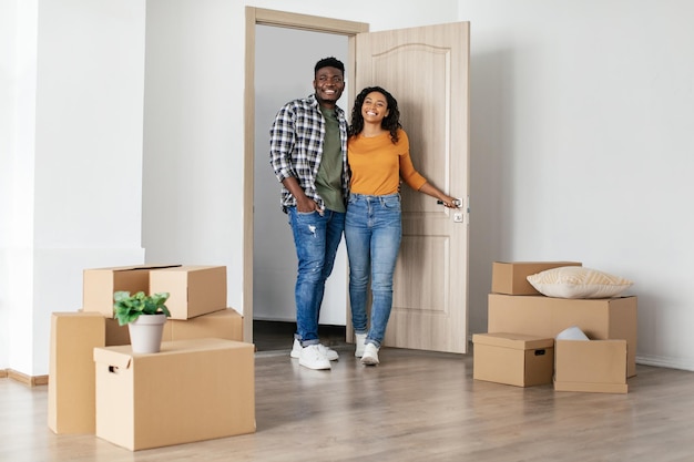 Feliz esposo y esposa negros mirando un nuevo hogar