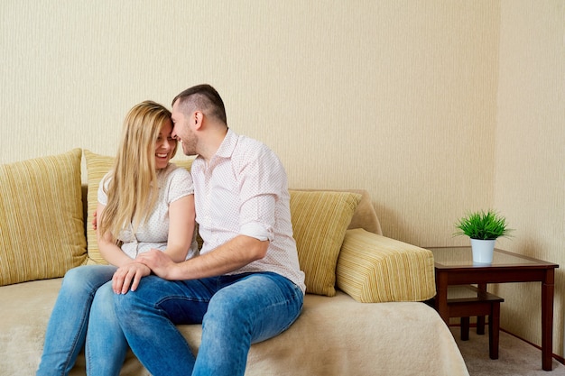 Feliz esposo y esposa sentados en la habitación