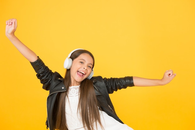 Feliz de estar aquí niño escuchar música rock pequeña escuela radio dj señora DJ cabello largo feliz sonrisa hipster estilo urbano chica estilo de vida concepto motociclista niño en auriculares niña pequeña en chaqueta de cuero