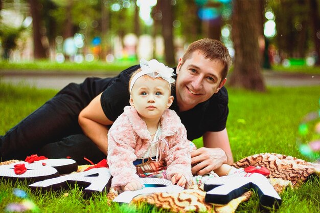 Feliz estilo de vida familiar, vacaciones. Madre, padre, niña caminando en la ciudad, parque verde. naturaleza muerta