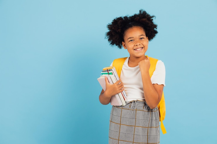 Foto feliz estudante afro-americana apontando legal em fundo azul de volta ao conceito da escola