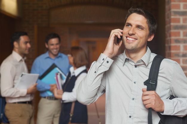 Feliz estudante maduro telefonando com seu smartphone