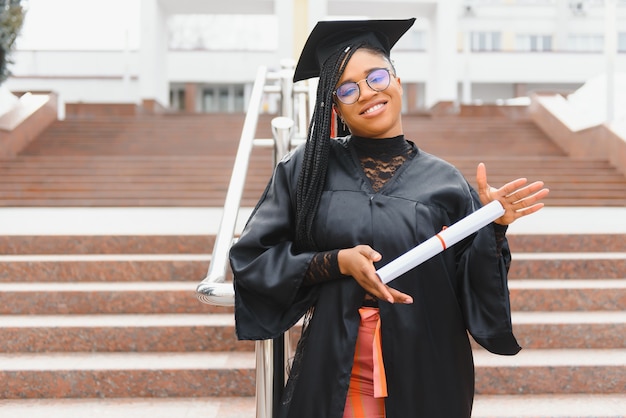 Feliz estudiante afroamericana con diploma de graduación