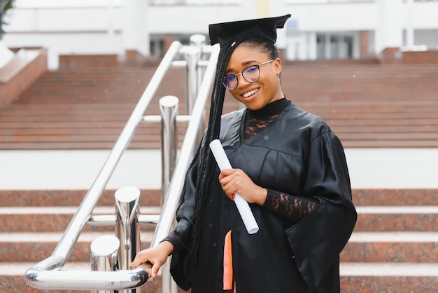 Feliz estudiante afroamericana con diploma de graduación