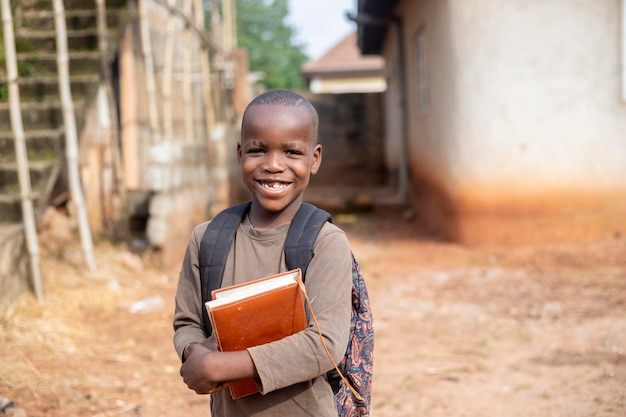 Feliz estudiante afroamericano de primaria ingresando a la escuela