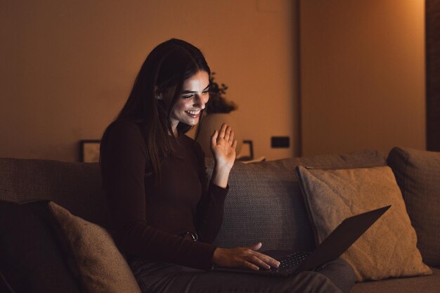 Feliz estudiante joven caucásica ver webinar escuchar curso en línea comunicarse por videoconferencia e aprender idiomas en la aplicación reír estudiar con el maestro lección mirar la computadora portátil por la noche xA