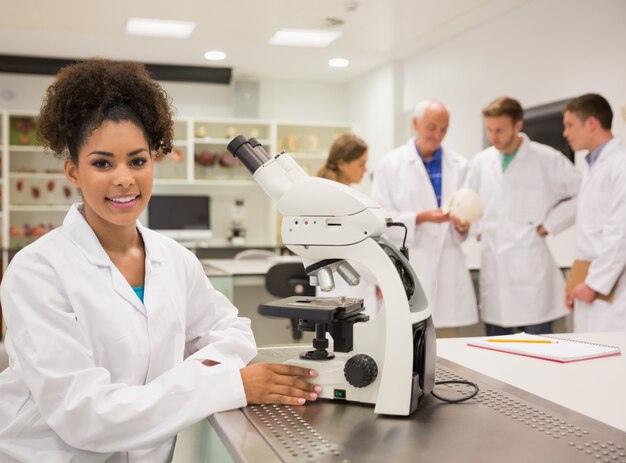 Feliz estudiante de medicina trabajando con microscopio