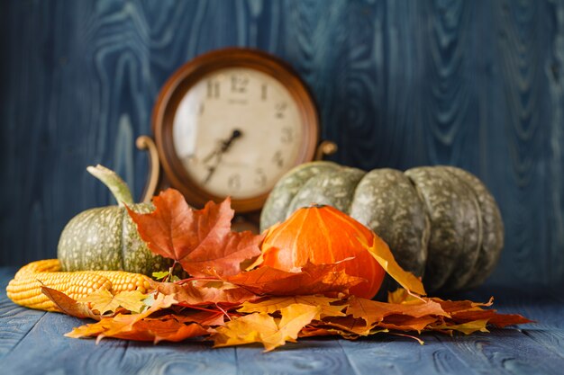 Feliz etiqueta de regalo de Acción de Gracias con doble borde de coloridas hojas y calabazas sobre un fondo de madera rústica