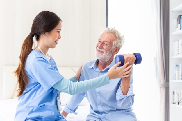 Feliz exame de saúde de um paciente masculino sênior e cuidado por uma jovem médica ou enfermeira em casa após a aposentadoria para uma boa saúde