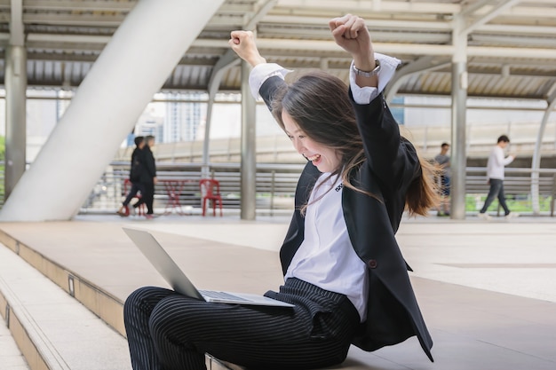 Feliz exitosa mujer de negocios con los brazos hacia arriba