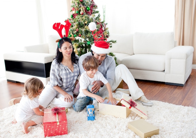 Feliz familia abriendo regalos de Navidad