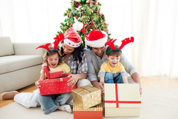 Feliz familia abriendo regalos de Navidad