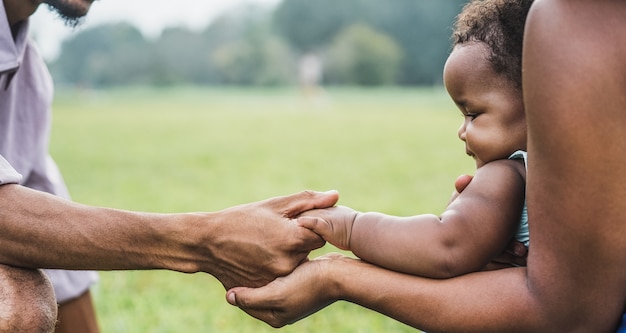 Feliz família africana explora as mãos juntas ao ar livre durante a mãe dayt