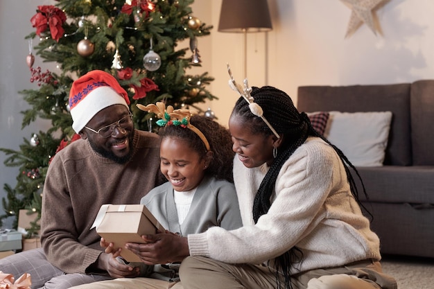 Feliz familia africana joven preparando regalos para navidad