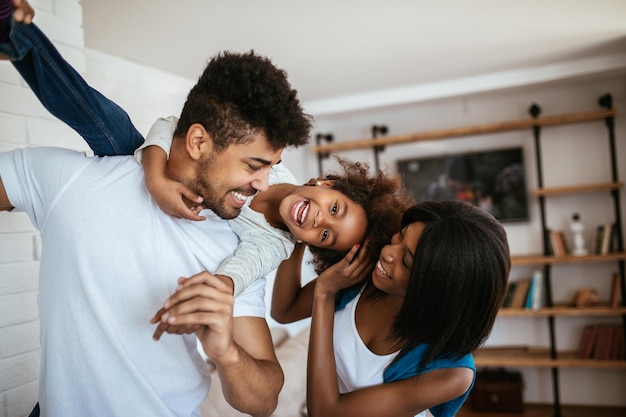 Feliz família afro-americana se divertindo em casa.