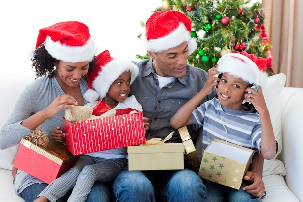 Feliz familia afroamericana jugando con regalos de Navidad