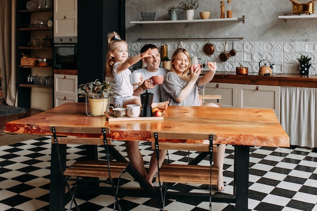 Una feliz familia alegre con un niño está cocinando la cena juntos en la cocina en casa