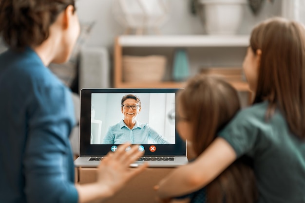 Foto feliz família amorosa jovem mãe e filhas meninas usando laptop pc para conversa remota