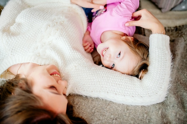 Feliz família amorosa. mãe e criança menina brincando, beijando e abraçando