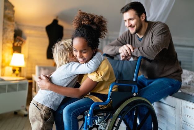 Foto feliz familia amorosa multiétnica. niña sonriente con discapacidad en silla de ruedas