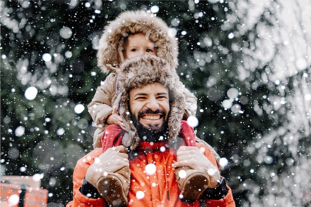 Feliz familia amorosa El padre y su bebé están jugando y abrazándose al aire libre Niño pequeño y papá en un paseo de invierno cubierto de nieve en la naturaleza Concepto de la primera nevada de invierno tan esperada