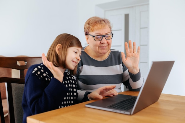 Feliz familia anciana y niño videollamada en su computadora portátil en casa