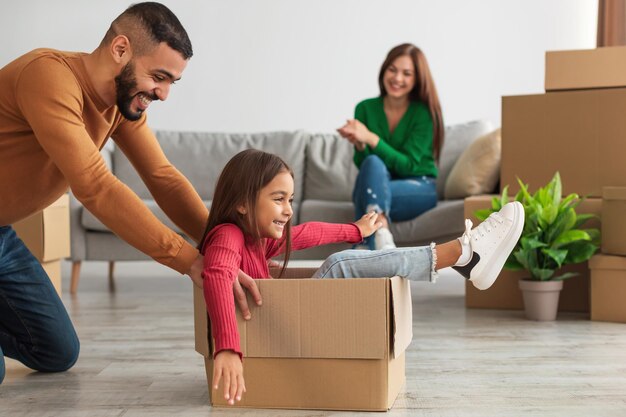 Feliz familia árabe celebrando el día de la mudanza en apartamento nuevo