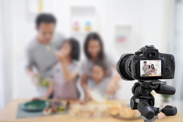 Feliz familia asiática haciendo una cámara digital Vlog video blogger con cocina en la cocina.