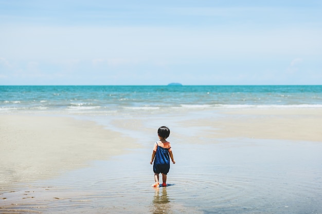 Foto feliz familia asiática niña relajarse y hacer turismo en la playa en el día en tailandia, concepto de vacaciones de viajes de verano