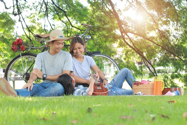 Feliz família asiática piquenique no conceito de relaxamento de companheirismo de parque