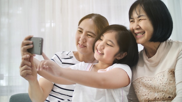 Foto feliz familia asiática tomar selfie foto juntos por teléfono inteligente, multi generación de asia