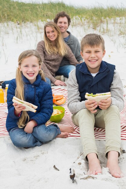 Feliz familia de cuatro en un picnic de playa