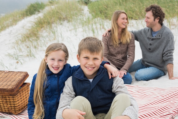 Feliz familia de cuatro en un picnic de playa