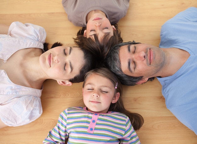 Foto feliz familia durmiendo tirado en el piso