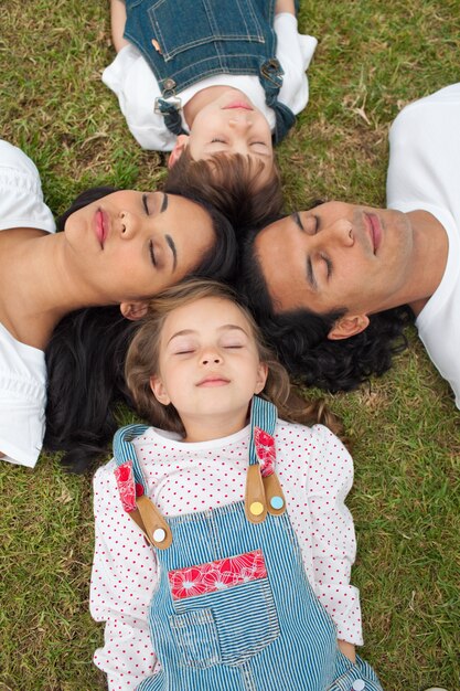 Feliz familia durmiendo tumbado en la hierba