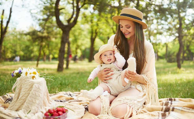 Feliz familia elegante y amorosa. Madre jugando con su bebé al aire libre. bebé encantador sonríe y disfruta. Concepto del día de la madre.