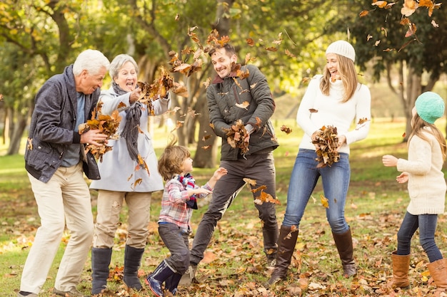 Feliz familia extendida arrojando hojas alrededor