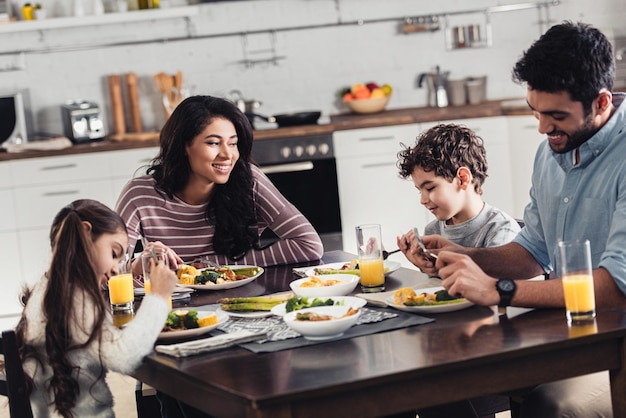 feliz família hispânica sorrindo enquanto almoçava em casa