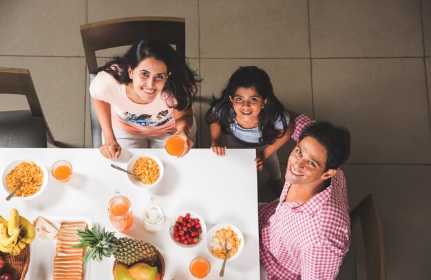 Feliz família indiana jovem asiática jantando em casa e se divertindo. foco seletivo