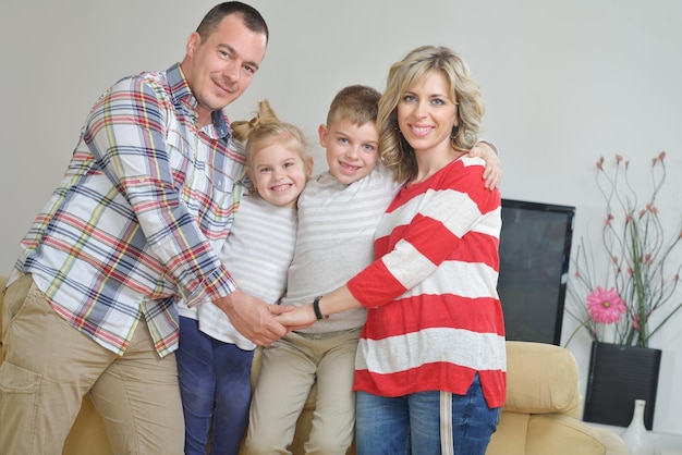 Foto feliz familia joven se divierte con sus hijos en la moderna sala de estar en el interior