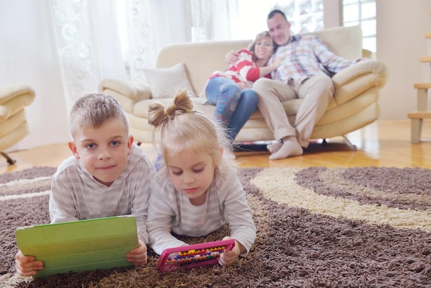 feliz familia joven se divierte con sus hijos en la moderna sala de estar en el interior