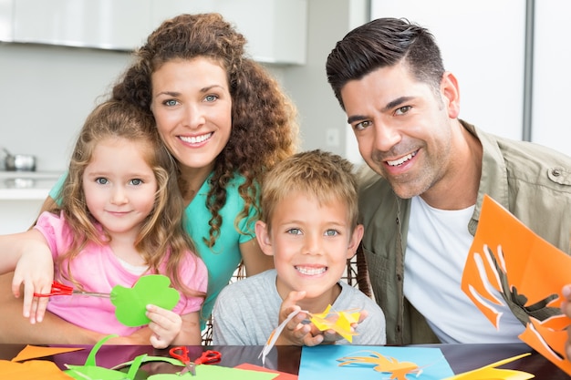 Feliz familia joven haciendo manualidades en la mesa