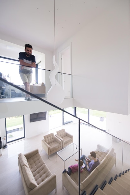 feliz familia joven con una niña pequeña disfruta en la moderna sala de estar de su villa de lujo