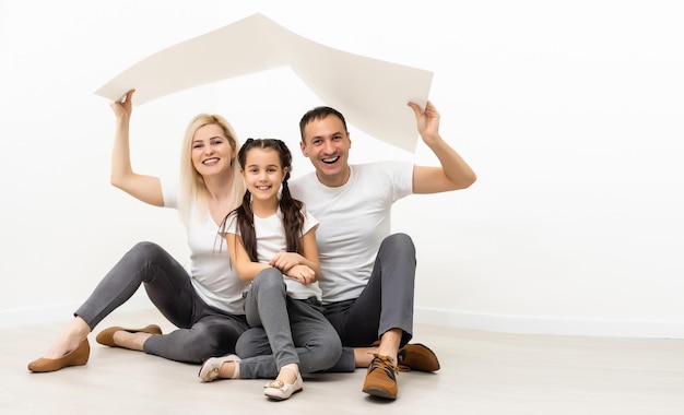 Foto feliz familia joven sentada en el suelo con el concepto de hogar.