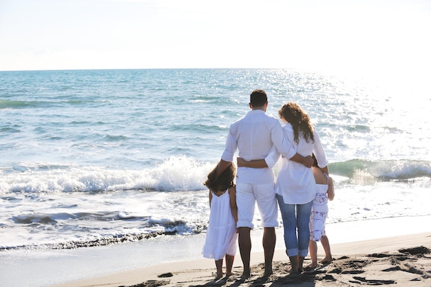 feliz familia joven vestida de blanco diviértete de vacaciones en una hermosa playa