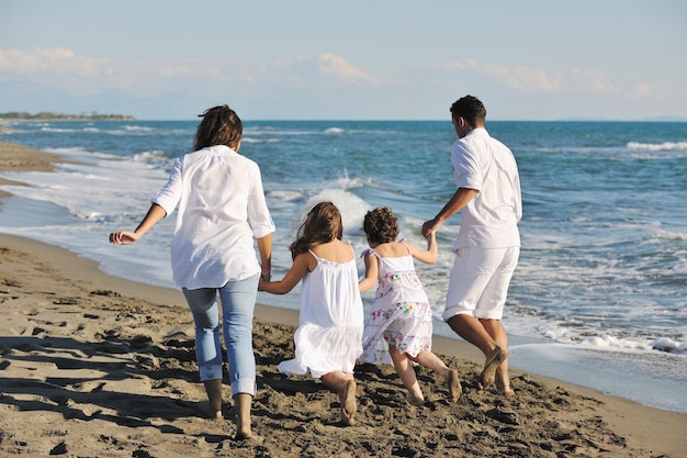feliz familia joven vestida de blanco diviértete de vacaciones en una hermosa playa